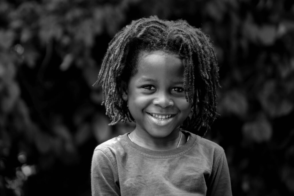 Black and white photo of boy looking into the camera and smiling
