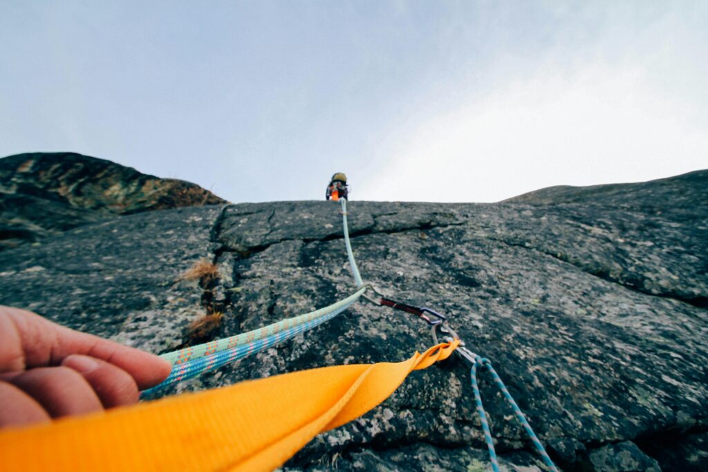 Close up perspective of a climber looking up a mountain face along the climbing ropes above